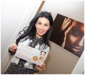 Astrid holding Le Prestige Medi Spa flyer